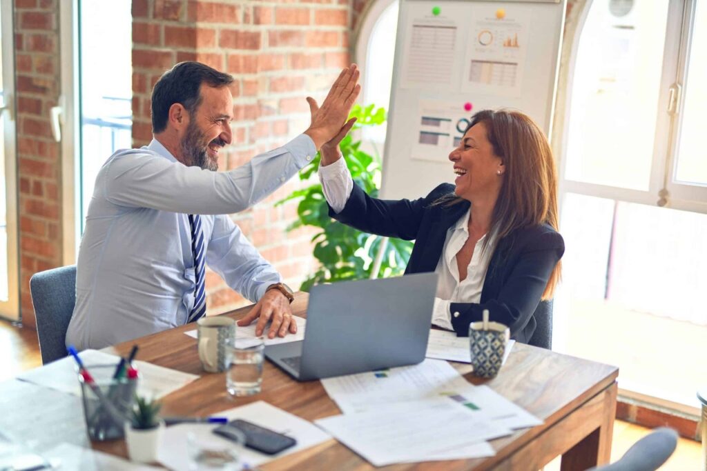 Erfolgspaar beim feiern von erfolgreichem umsetzen Ihres LinkedIn Potenzial.